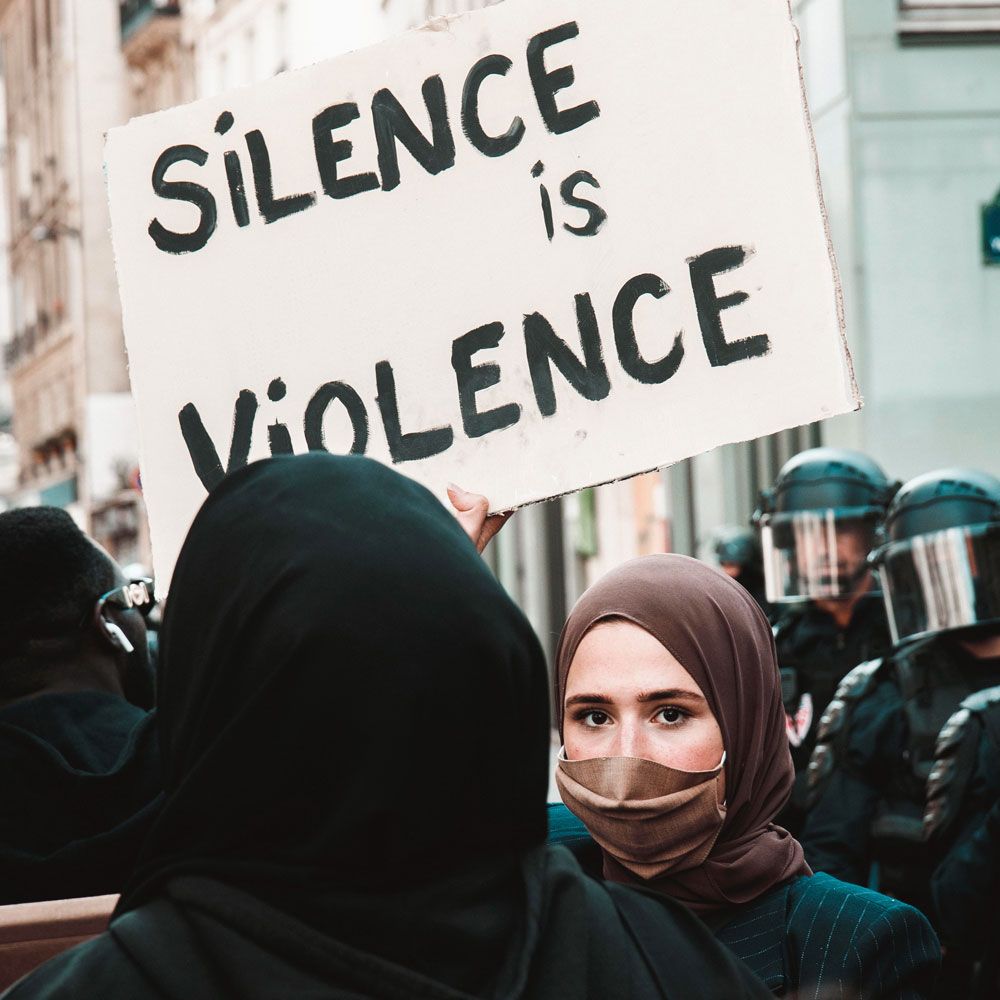 Imagen de mujer musulmana con cartel "Silence is Violence" 